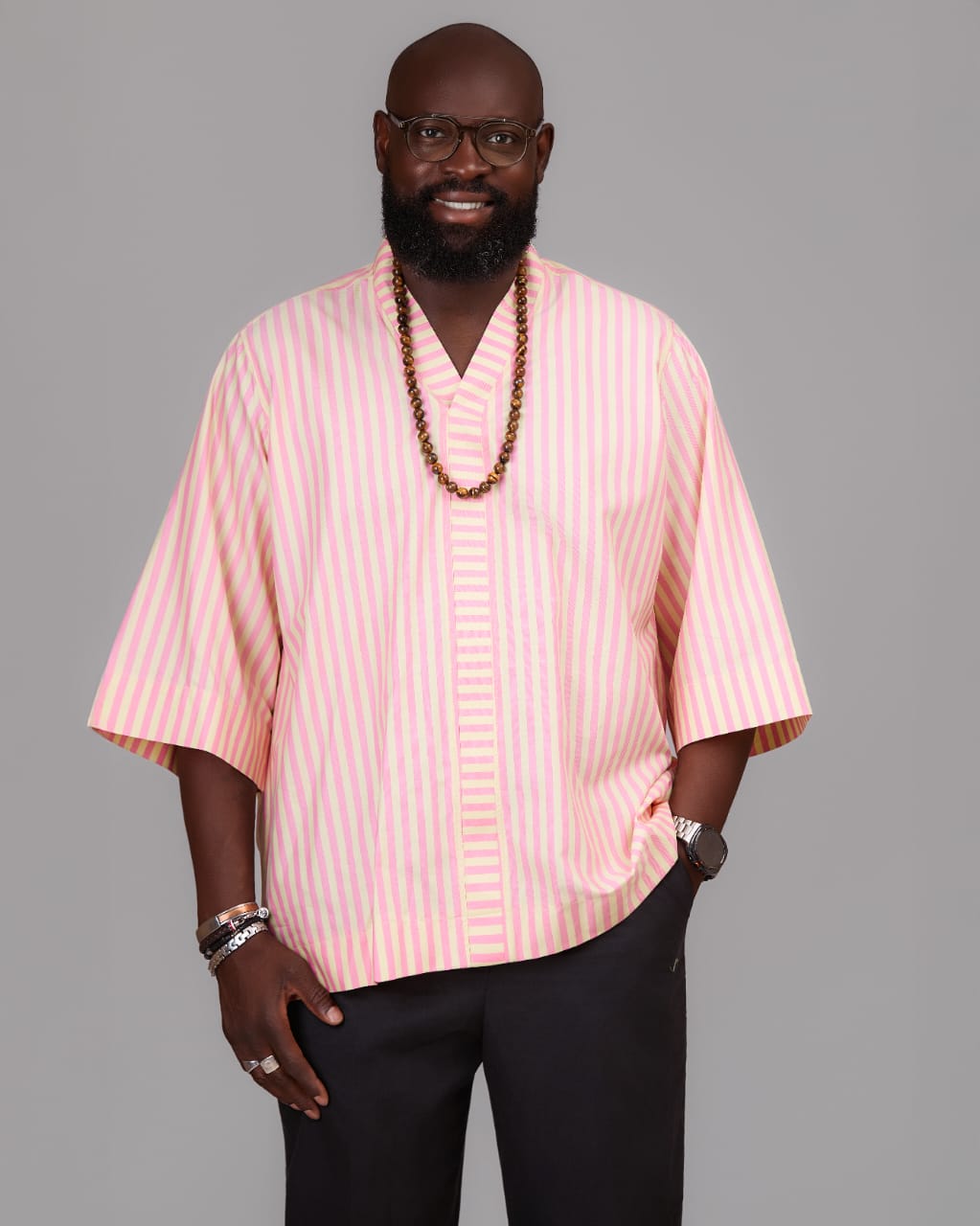 Créateur XƆVI en chemise kimono rayée rose et ivoire, affirmant sa singularité